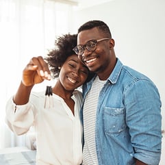 couple holding key to new home